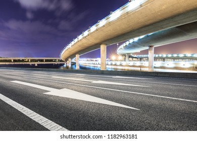 Asphalt road and modern bridge building scenery at night