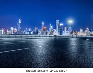 Asphalt road and modern city buildings at night in Shenzhen, China. - Powered by Shutterstock