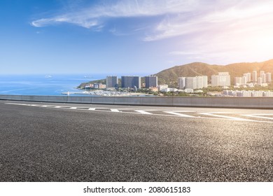 Asphalt Road And Modern City Commercial Buildings With Skyline By The Sea