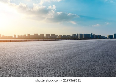 Asphalt road and modern city skyline with buildings scenery at sunset - Shutterstock ID 2199369611