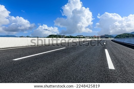 Asphalt road and mountain with building scenery under the blue sky