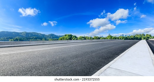 Carretera asfaltada y montaña con paisaje urbano