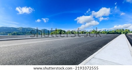 Asphalt road and mountain with city skyline scenery