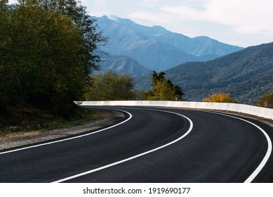 Asphalt road. Paved road on the background of mountains. Road on the background of beautiful mountains in the Caucasus. Landscapes of the country. Journey through beautiful places by car. Copy space - Powered by Shutterstock