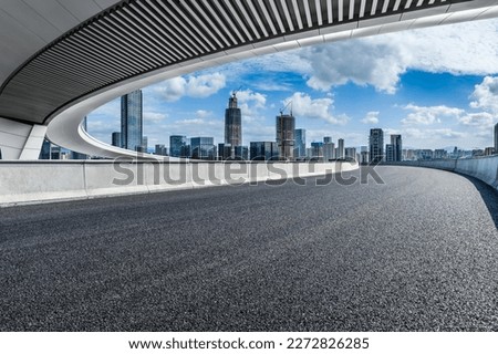Asphalt road and pedestrian bridge with modern city skyline in Ningbo, Zhejiang Province, China. 