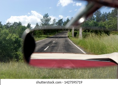 Asphalt Road In The Rearview Mirror. Rear View Mirror In The Cabriolet