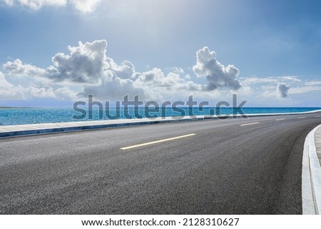 Asphalt road and sea natural scenery under blue sky