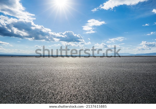 Asphalt road and\
sky clouds with sun\
landscape