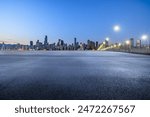 Asphalt road square and modern city buildings at night. Road and city skyline background.