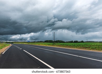 Asphalt Road And Stormy Sky In Background.