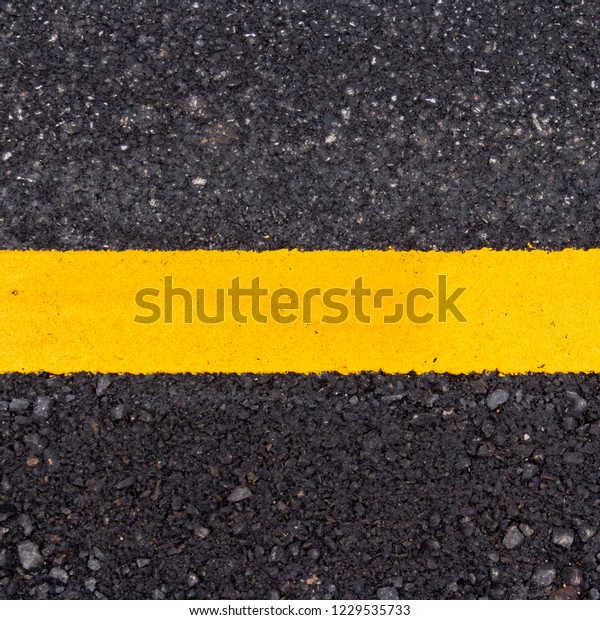 Asphalt road surface with\
yellow line