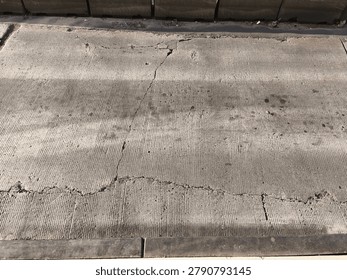Asphalt Road Texture with Grooved Pattern and Concrete Curb - Urban Street Detail, Close-up detailed texture of an asphalt road surface with visible grooved patterns, small debris, and concrete curb. Ideal for urban backgrounds, graphic design, architecture, and 3D rendering projects.