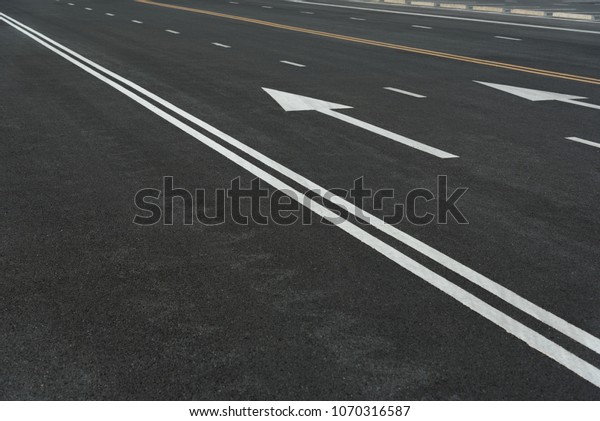 Asphalt road texture with white stripe, yellow\
strip, Road way background texture and Traffic sign. Traffic lines\
on the street.