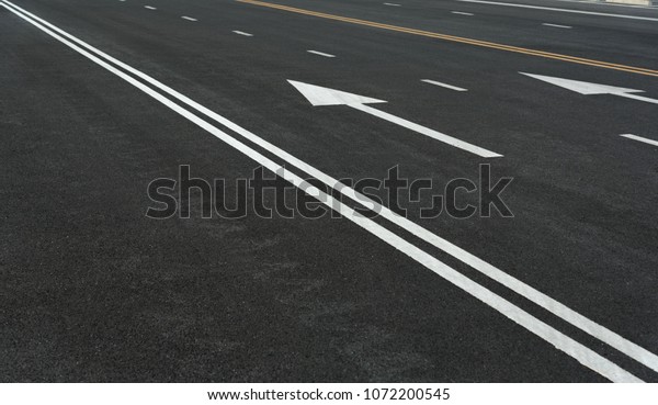 Asphalt road texture with white stripe, yellow\
strip, Road way background texture and Traffic sign. Traffic lines\
on the street.
