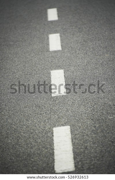 Asphalt road texture with white stripe. Low depth\
of field
