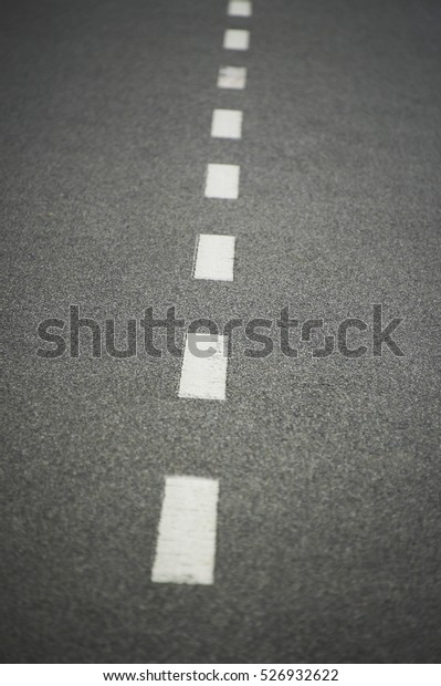 Asphalt road texture with white stripe. Low depth
of field