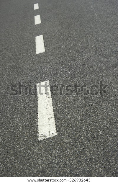 Asphalt road texture with white stripe. Low depth\
of field