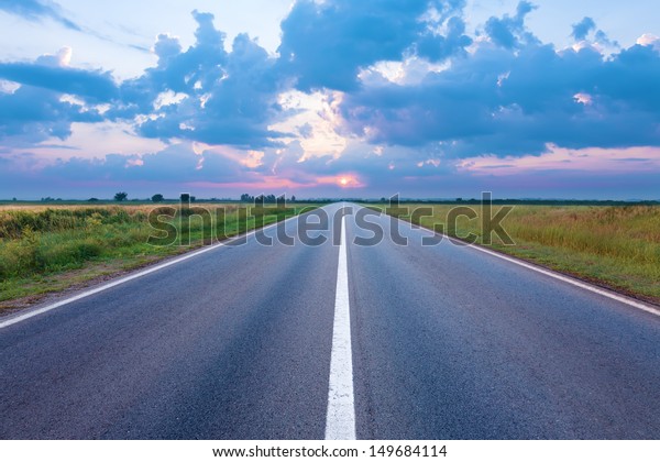Asphalt road towards the\
rising sun