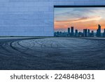 Asphalt road and wall with city skyline at night in Shanghai, China.