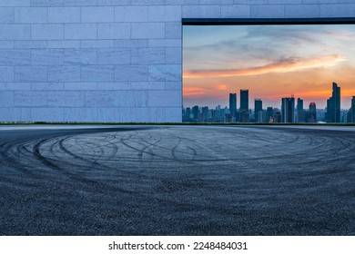 Asphalt road and wall with city skyline at night in Shanghai, China.