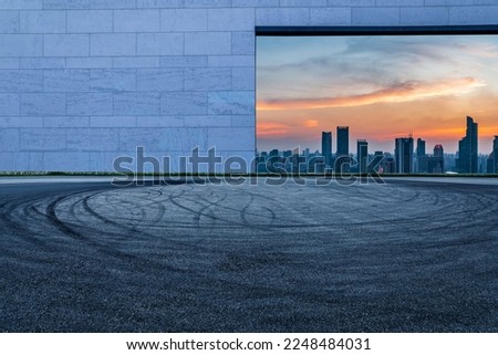 Asphalt road and wall with city skyline at night in Shanghai, China.