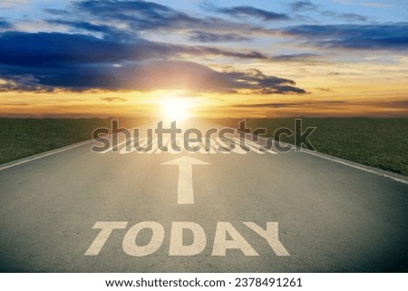 Asphalt road with white arrow sign and today to future text goes to horizon. Sunshine on horizon and the road straight away forward. Clear and positive perspectives ahead.