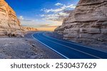 Asphalt road and Yardang landform mountain natural landscape at sunrise. road trip.