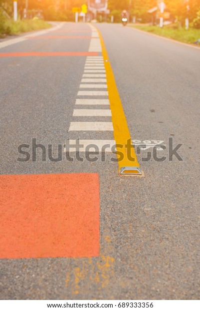 Asphalt\
road and Yellow divide lines on the highway\
.