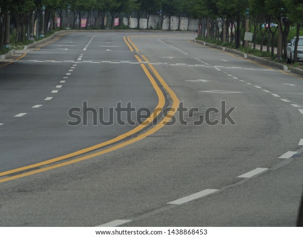 asphalt road with yellow double line and white
broken line, curved