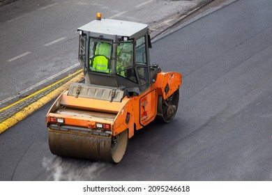Asphalt roller working on pavement of a road  High angle view