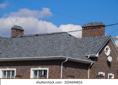 Asphalt Shingle. Decorative Bitumen Shingles On The Roof Of A Brick House