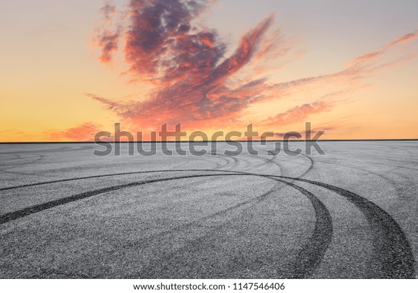 Asphalt square car tire brakes and beautiful\
colorful sky clouds at\
sunrise