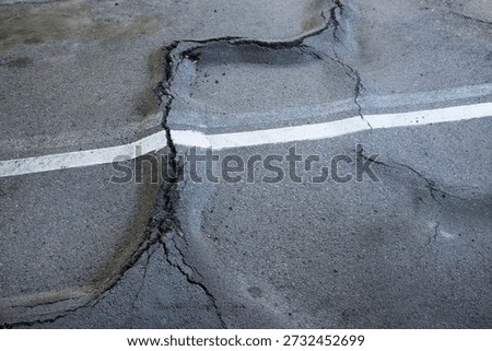 asphalt surface broken by root heave