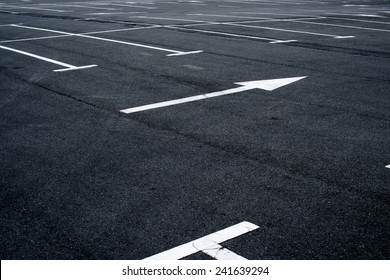 Asphalt surface of the empty parking with white road marking lines