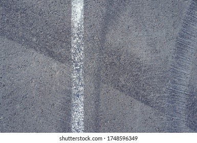 Asphalt Texture With White Line And Tire Marks.  Smooth Asphalt Road. Tarmac Dark Grey Grainy Road Background.Top View