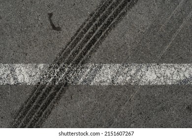 Asphalt texture with white line and tire marks. Smooth asphalt road. Tarmac dark grey grainy road background.Top view - Shutterstock ID 2151607267