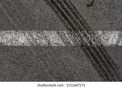 Asphalt Texture With White Line And Tire Marks. Smooth Asphalt Road. Tarmac Dark Grey Grainy Road Background.Top View