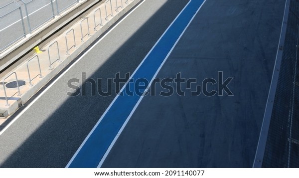 Asphalt track pit stop lane in racing circuit,
selective focus.	