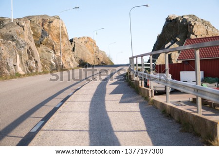 asphalt walking lane and road between mountains in sweden