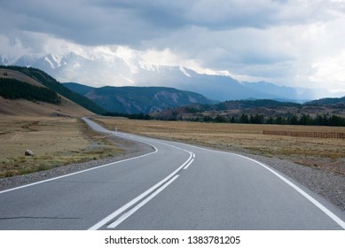 Asphalt winding road in the mountainous area Altai in the summer and blue sky with clouds