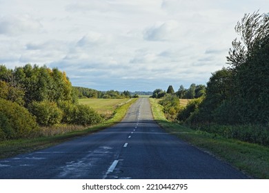 Asphalted Country Road With Green Trees On Roadsides In Perspective At Cloudy Autumn Day. Car Tourism