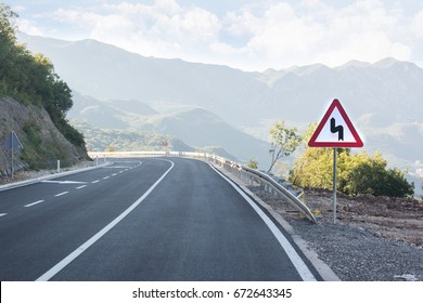 Asphalted Mountain Road With Sharp Sharp Turn Near The Cliff. Traffic Sign