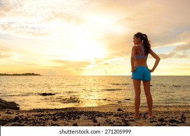 Aspirations - woman looking away with inspiration. Fitness woman after run in sunset on beach looking at ocean feeling peaceful and serene relaxing during summer. Mindfulness concept.