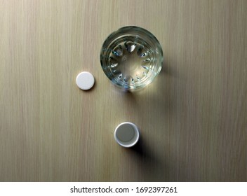 
Aspirin And A Glass Of Water Lie On The Table