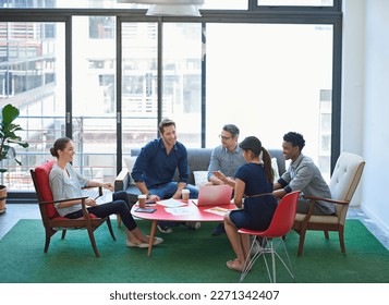 An assemblage of sharp minds. a group of office workers talking together in a meeting room.
