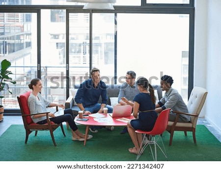 An assemblage of sharp minds. a group of office workers talking together in a meeting room.