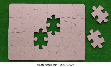 Assembled cardboard puzzles, two missing elements on a green background. interaction, set.