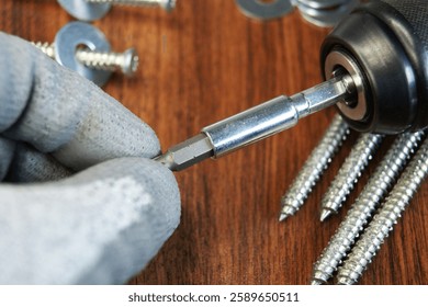 Assembler's work process. Removing the Torx bit from the bit adapter. 