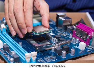 Assembling high performance personal computer, inserting CPU, processor into the motherboard socket, opened PC case in background, shallow depth of field, focus on hand - Powered by Shutterstock