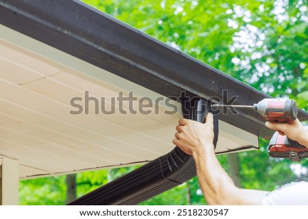 Assembling installing gutter channels on roof of home